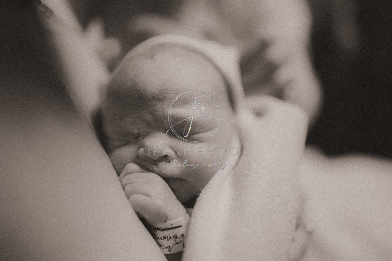 Details of a sleeping newborn baby sleeping on mom's chest