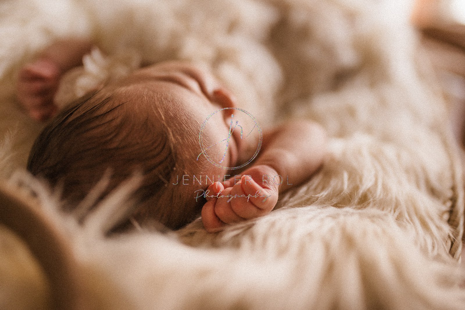 A newborn baby sleeps on a fur blanket before meeting Big Sky Nanny