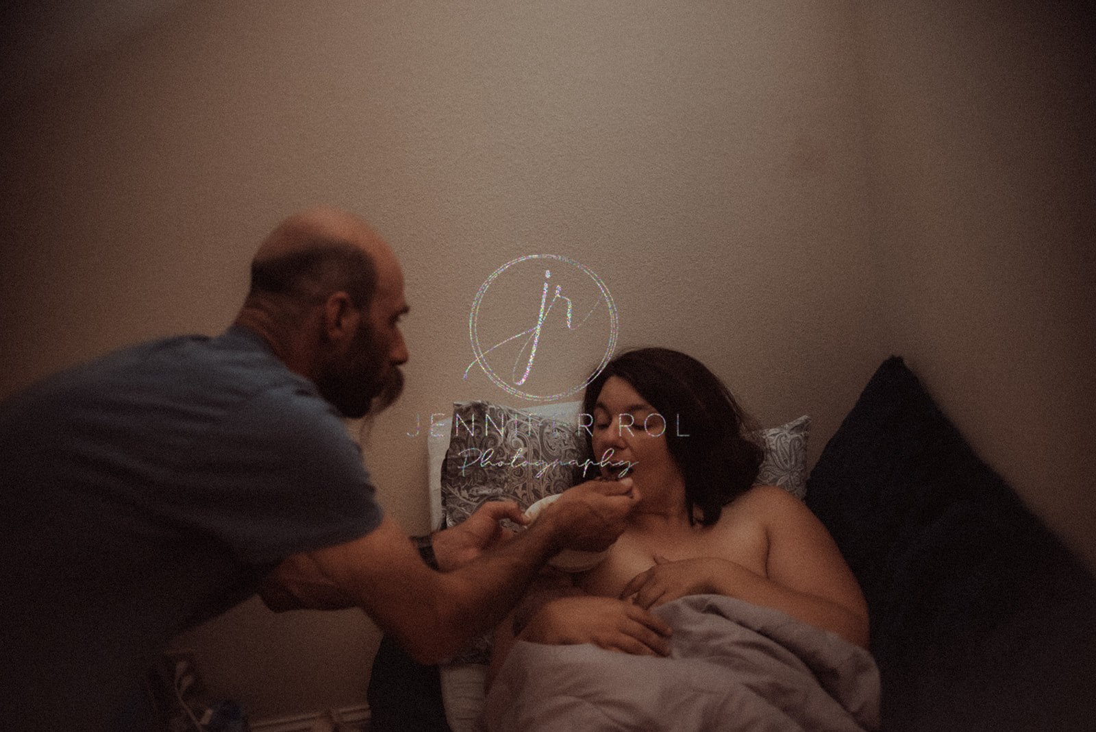 A new father feeds his nursing wife right after delivery with an OBGYN in Missoula