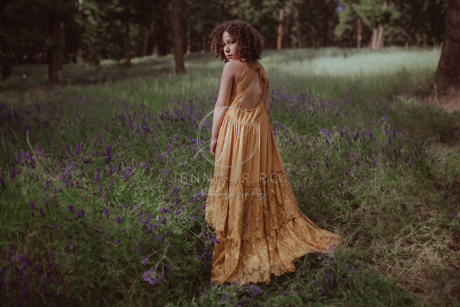 A young girl walks through a field of purple wildflowers in a yellow dress before visiting a Children's Museum in Missoula