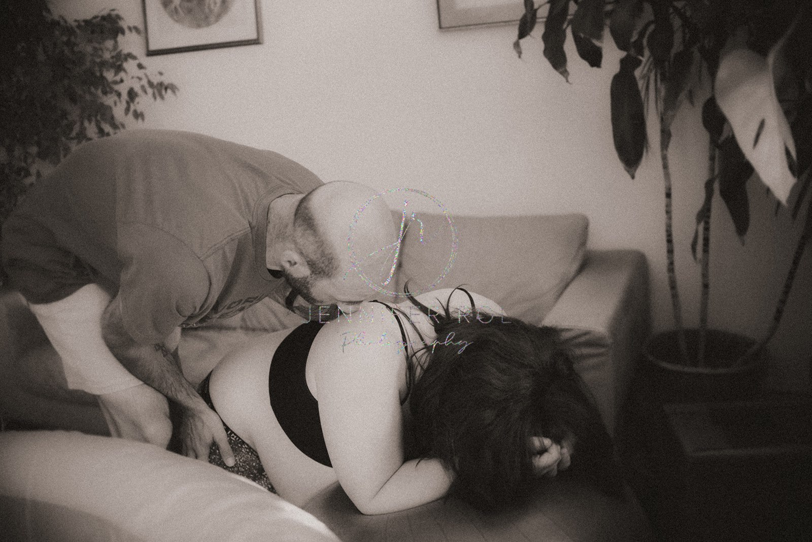 A dad to be helps support his wife as she leans on a workout ball in a birth center during contractions