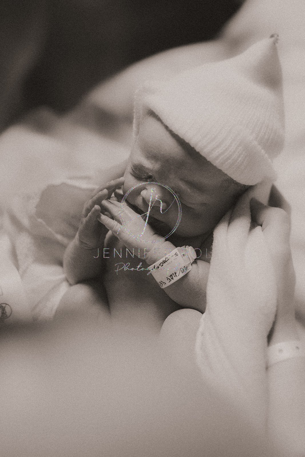 A newborn baby sleeps in mom's hands on the delivery room bed before finding a diaper service in Missoula