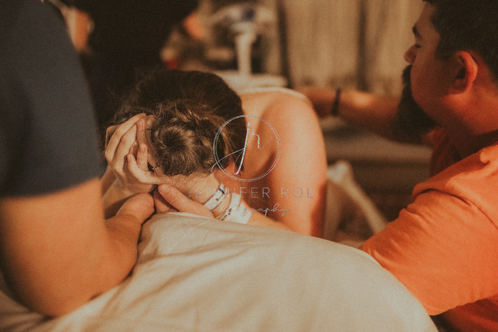 A mom to be struggles with contractions in the delivery room with her husband comforting her on the bed after some prenatal yoga in Missoula