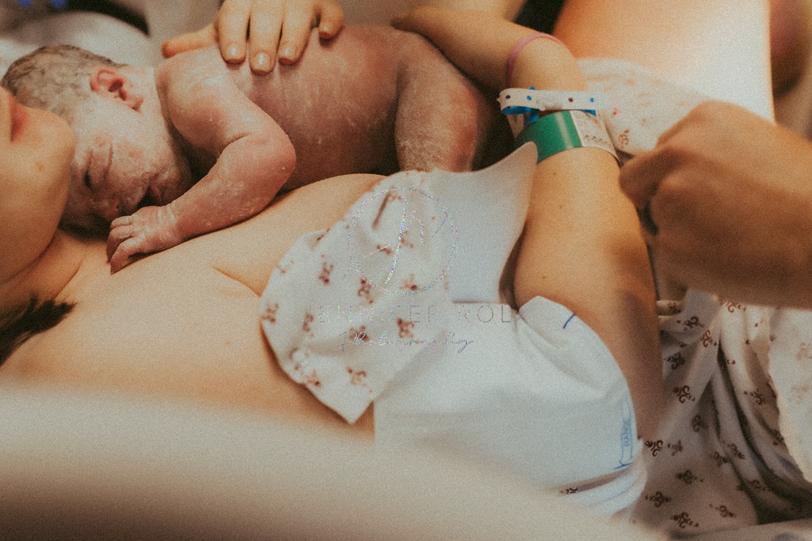 A new mom cradles her newborn baby against her chest in the hospital room right after delivery