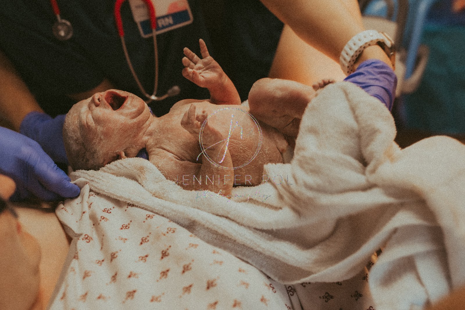 A newborn baby cries while being cleaned after birth with help from Roots Birth Missoula