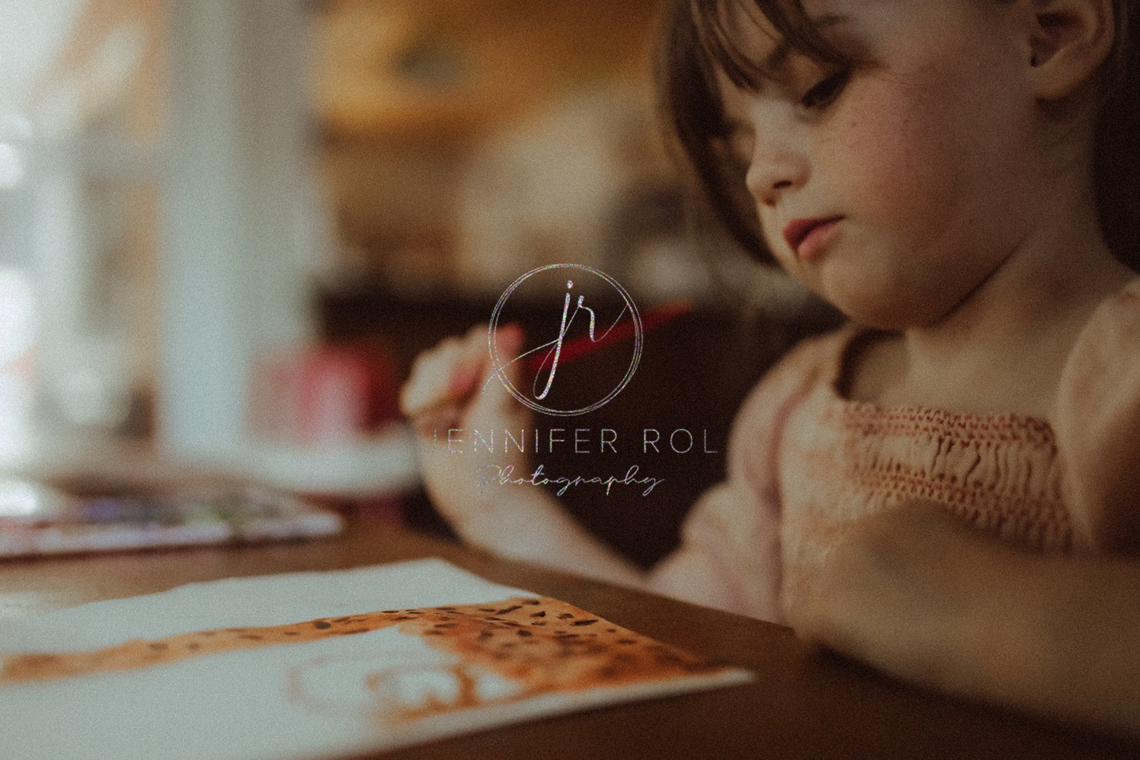 A peek of a girl in an orange dress painting a giraffe with watercolor after visiting Toy Store in Missoula