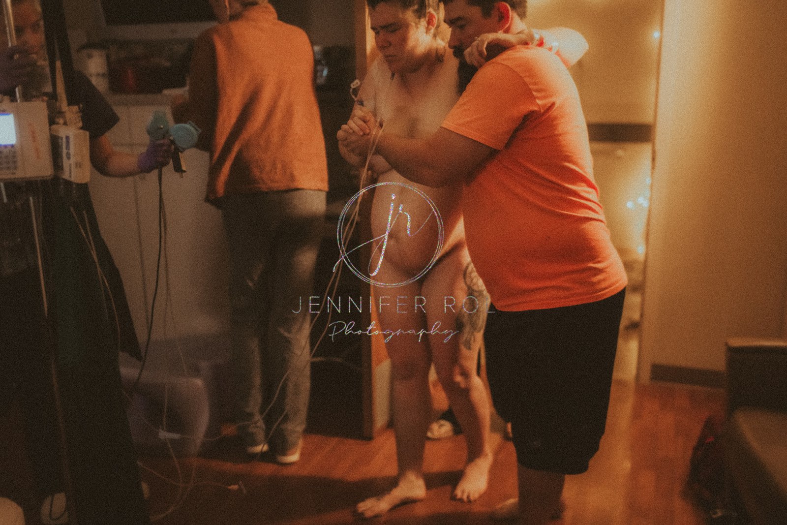 A man helps his wife walk naked in delivery room for birth with help from Feral Mother Doula