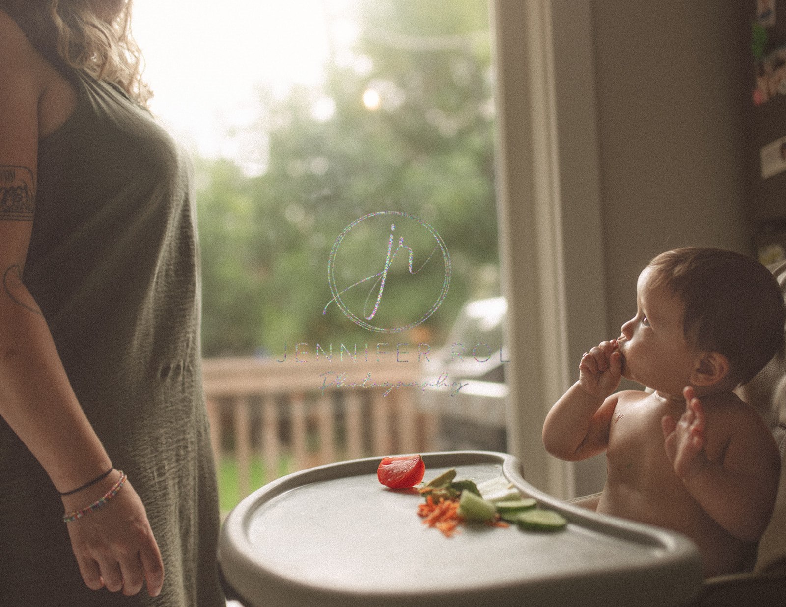 A mom looks over her baby eating vegetables in a high chair in the kitchen after finding great baby furniture in Missoula, MT