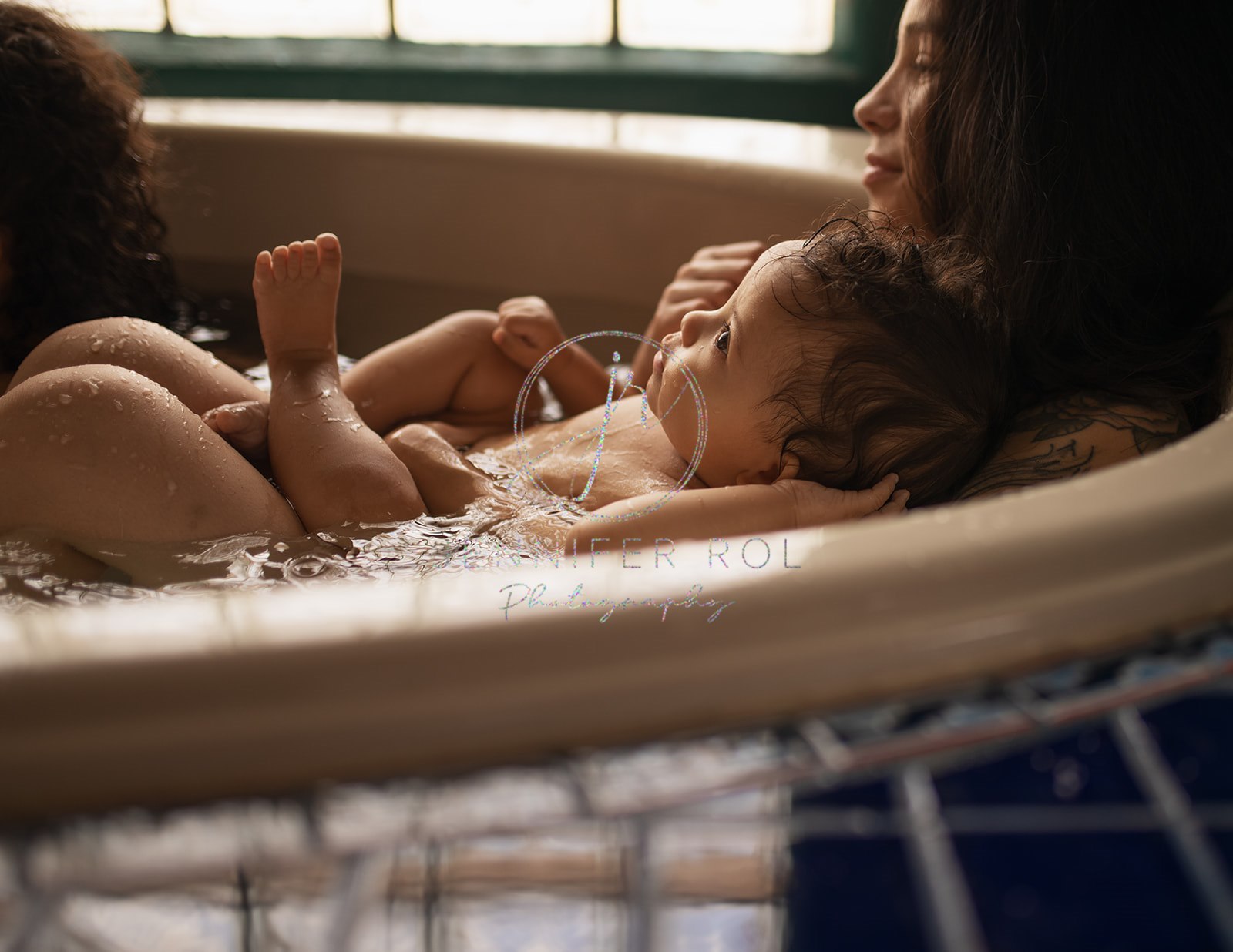 A baby lays on mom's chest as they take a bath together after using Jess4Sleep Consulting