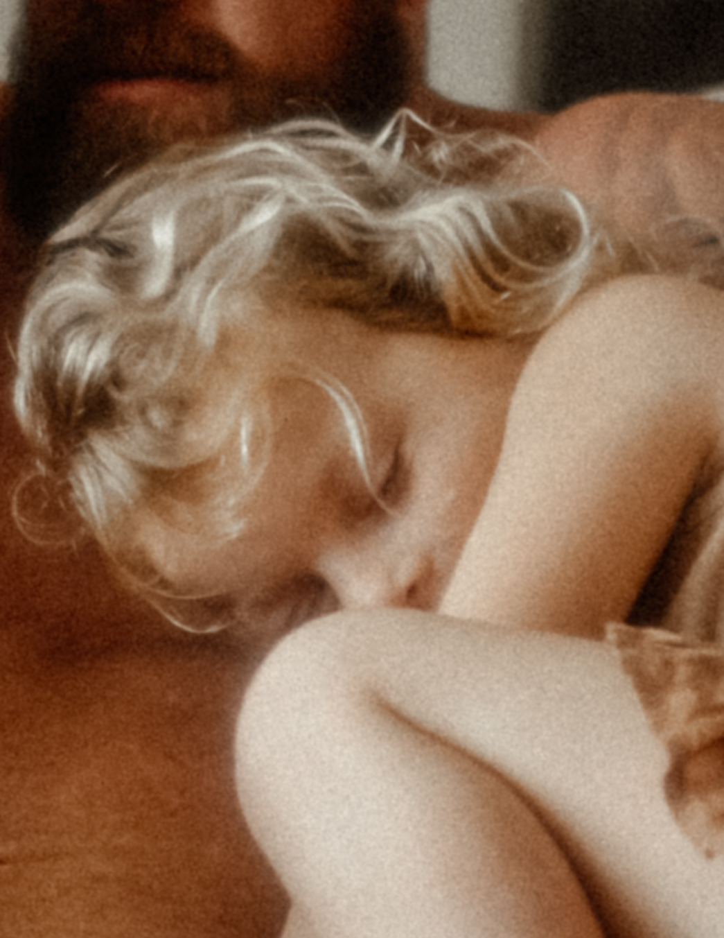 A young girl sleeps curled up on the couch in a dress