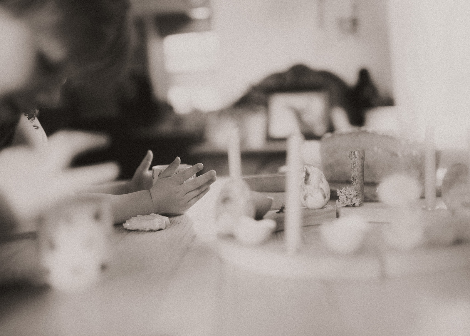 Details of a toddler holding a cup at the dining room table decorated with eggs and candles