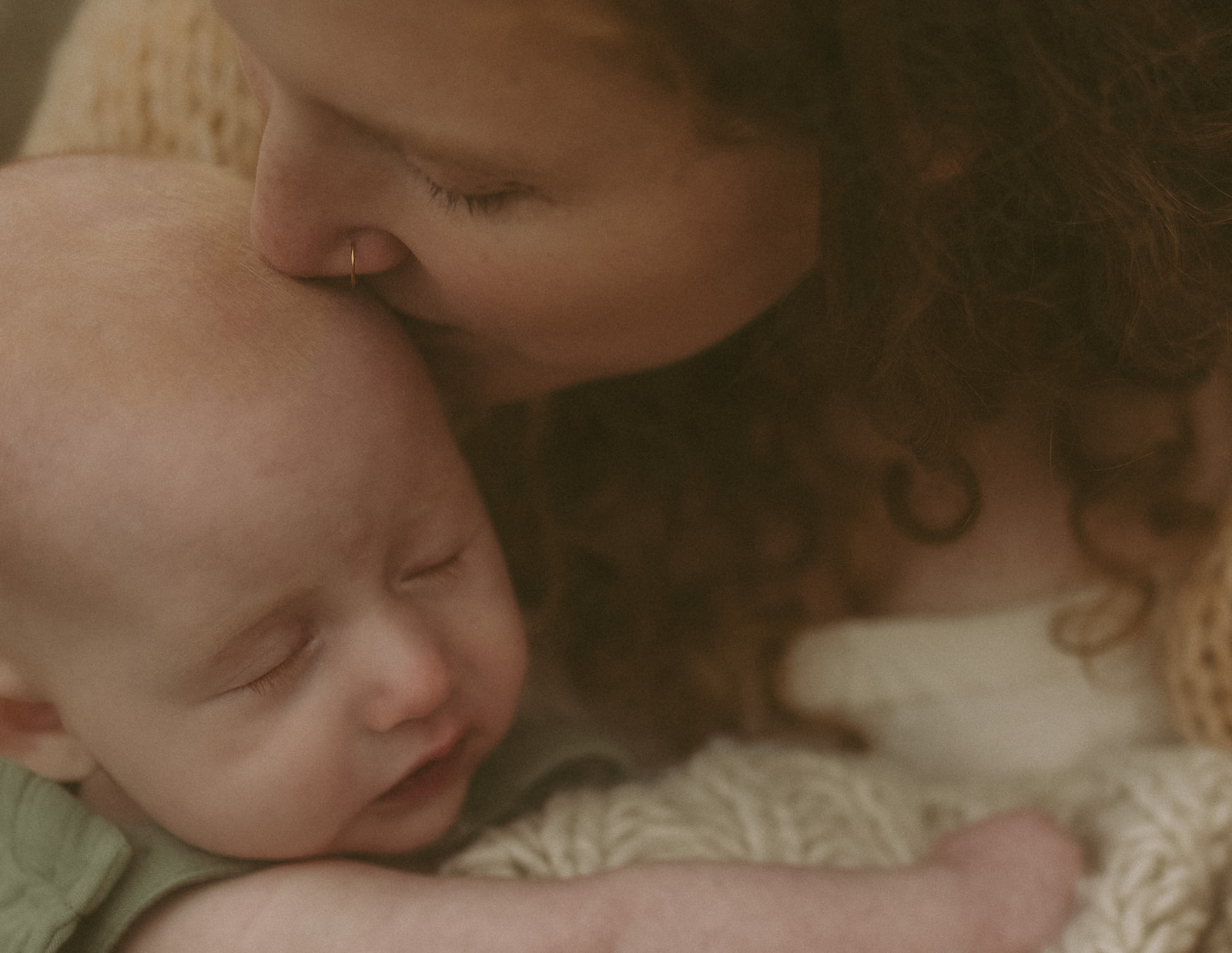 An infant hugs mom as she kisses her head thanks to a prenatal chiropractor in Hamilton, MT