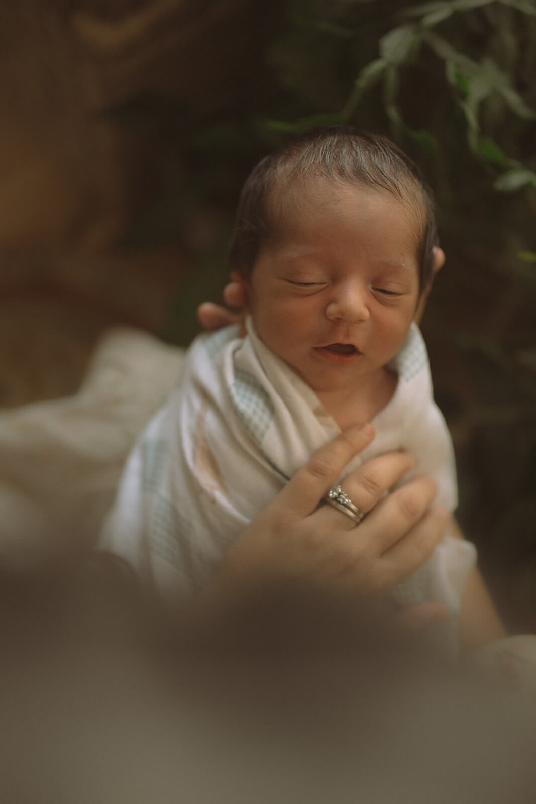 A look down to a sleeping newborn in mom and dad's hands after visiting handmade montana
