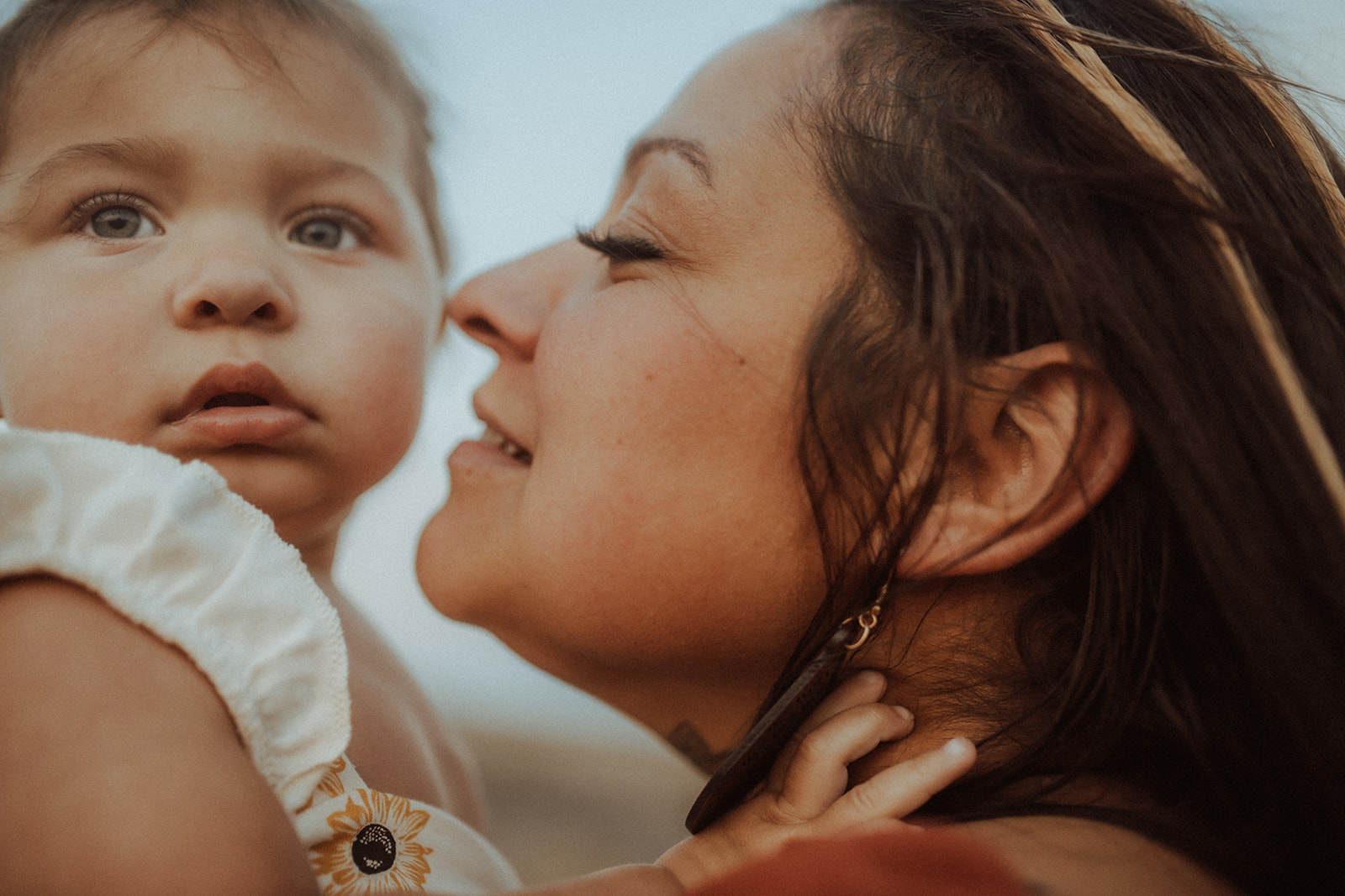 A mother leans in to kiss her toddler daughter on the cheek after visiting head over heals in Polson
