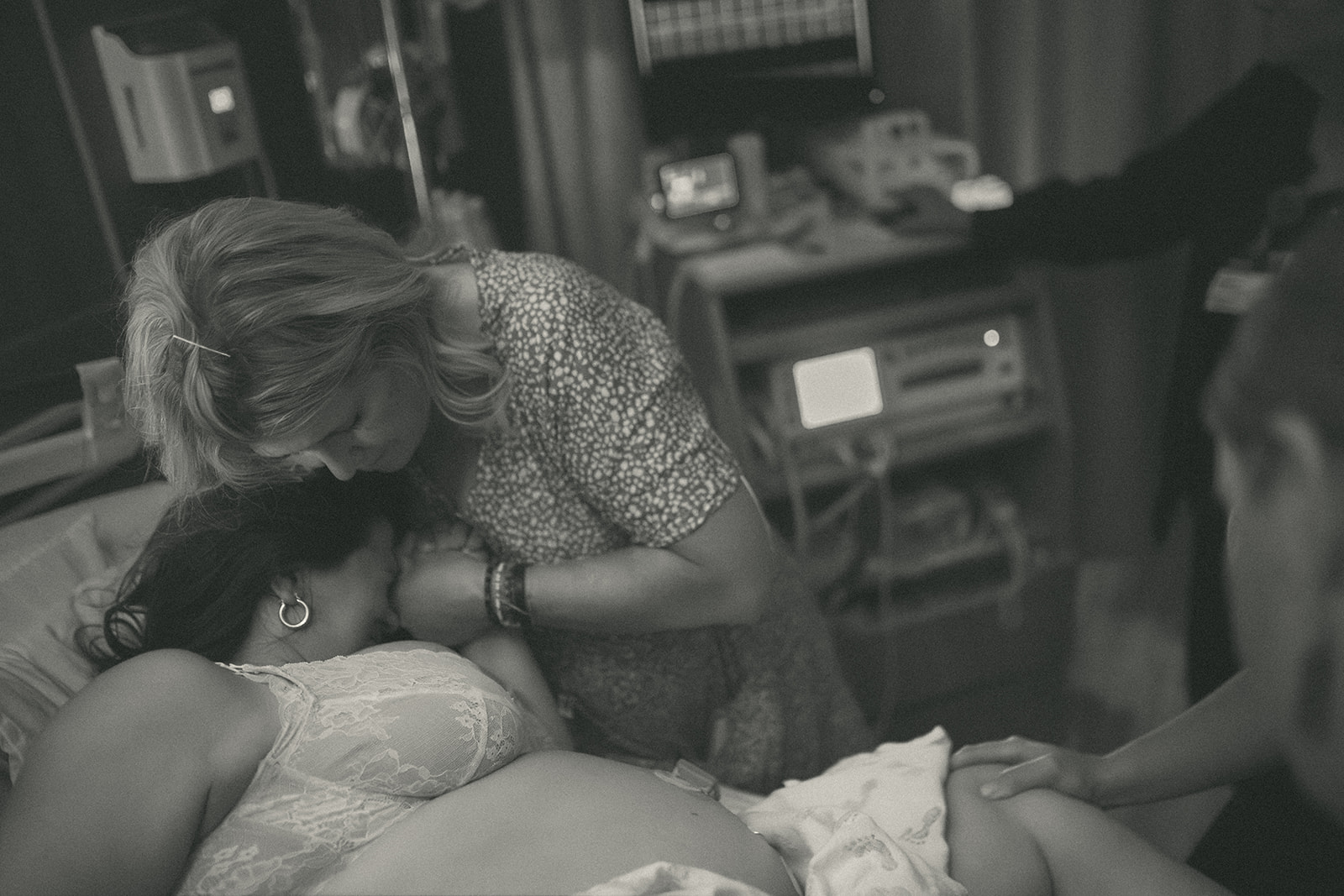 A pregnant woman in labor holds hands and takes comfort in mom on the hospital bed at one of the birthing centers in Kalispell, MT