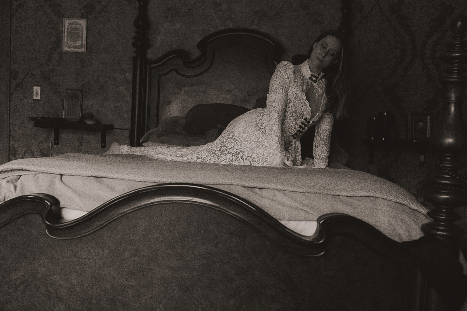 A woman in a lace gown kneels on a bed after visiting bridal shops in Montana