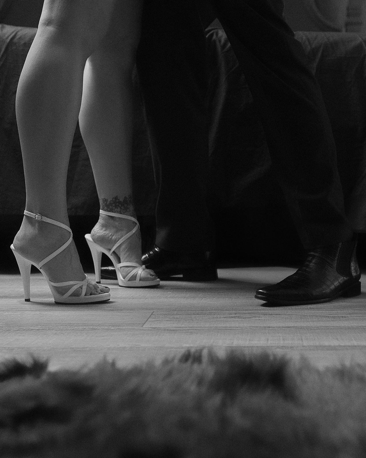 Details of a man and woman's feet in white heels and leather shoes from bridal shops in Montana