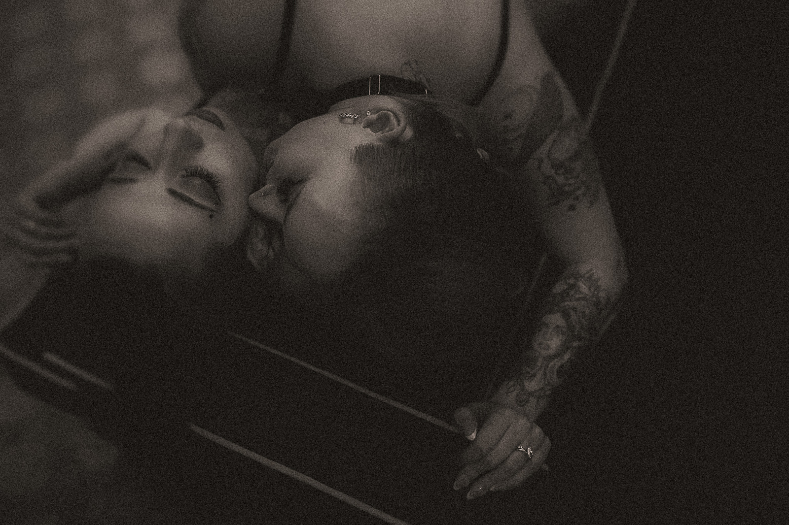 A couple snuggles in a dark room after visiting hair salons in MIssoula