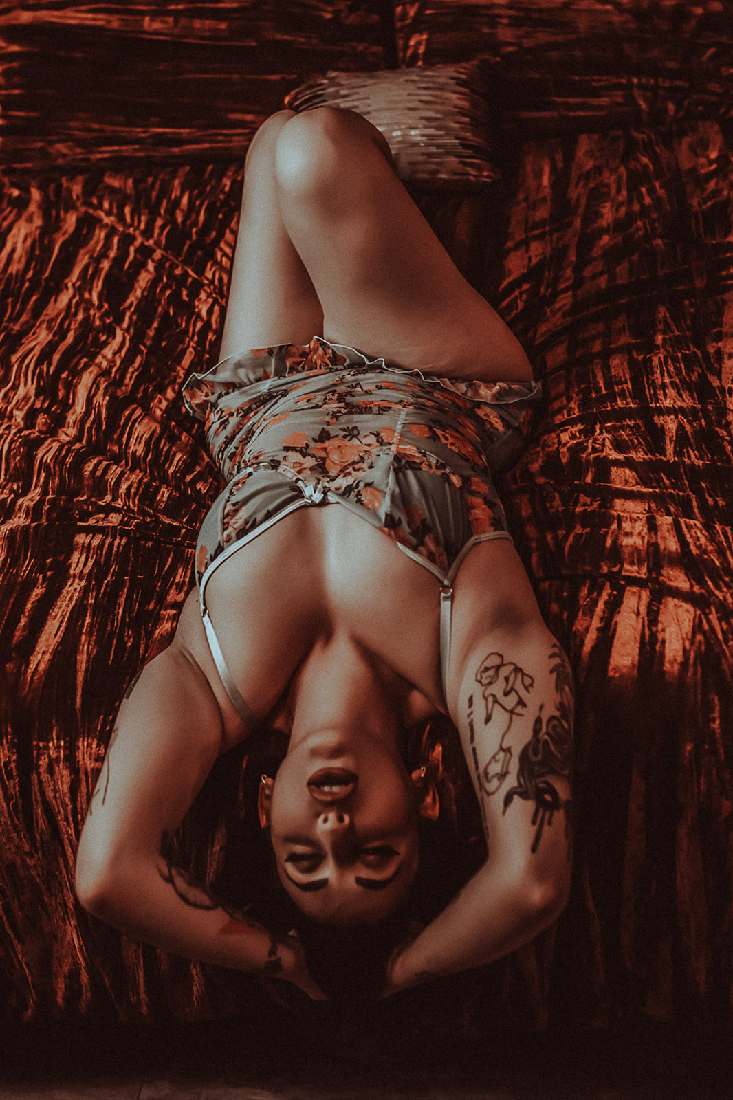 A woman in floral lingerie lays back on a red bed at Missoula boutique hotels