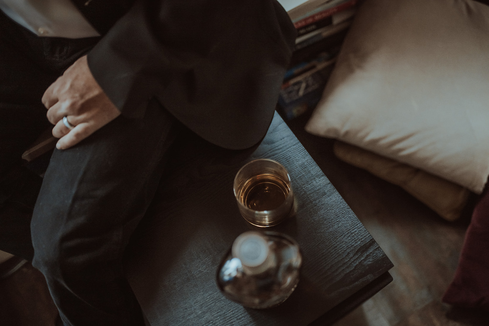 Details of a whiskey on a table a man is sitting on in a suit at Missoula Luxury Hotels